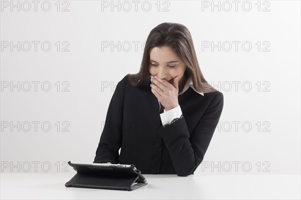 Smiling young woman using digital tablet. Photo : Jan Scherders