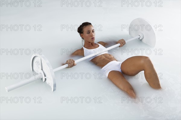 Young woman weight lifting in water. Photo : King Lawrence