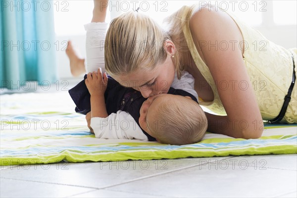 Young mother kissing daughter. Photo: Mark de Leeuw