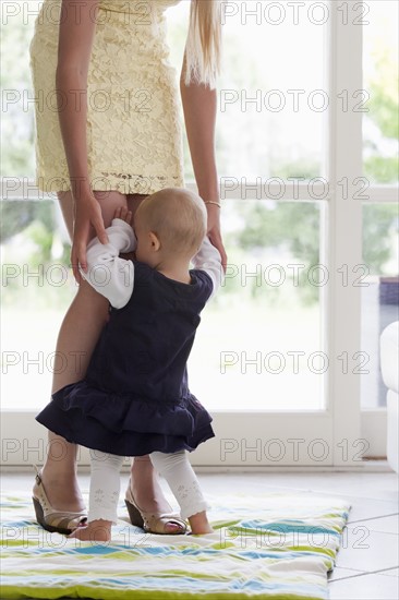 Baby seeking protection at her mothers legs