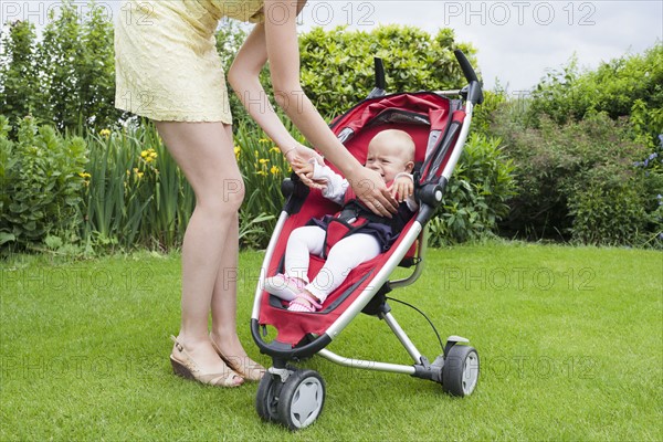 Mother comforting crying girl in pram. Photo : Mark de Leeuw