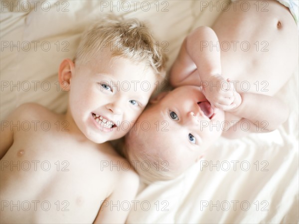 Portrait of boy (2-3) with baby sister (6-11 months). Photo : Jessica Peterson