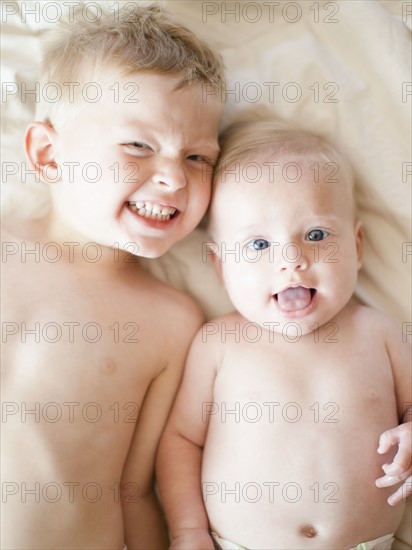 Portrait of boy (2-3) with baby sister (6-11 months). Photo : Jessica Peterson