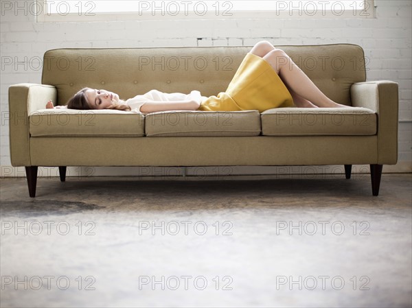 Young woman lying on sofa. Photo : Jessica Peterson