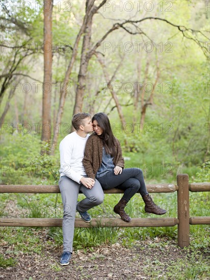 Young couple sitting on fence. Photo: Jessica Peterson