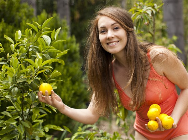 Young woman with fresh picked orange. Photo : Jessica Peterson