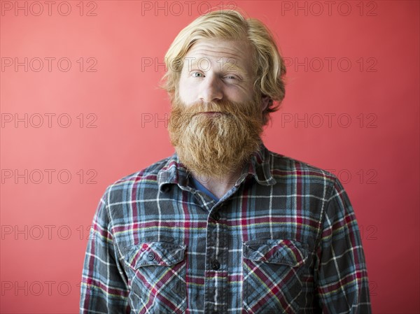 Portrait of smiling man with beard, studio shot. Photo: Jessica Peterson