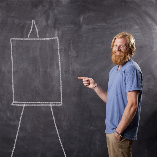 Man in front of blackboard pointing. Photo : Jessica Peterson