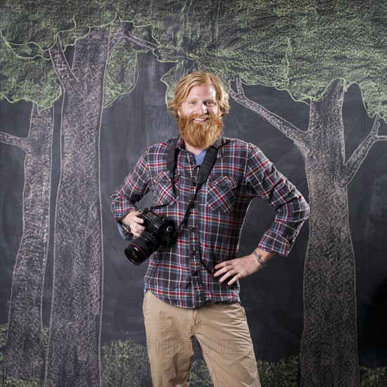 Man in front of blackboard taking pictures. Photo: Jessica Peterson