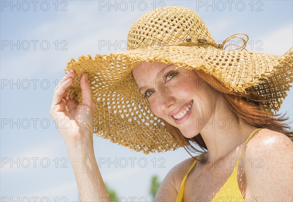 Portrait of woman wearing straw hat. Photo: Tetra Images