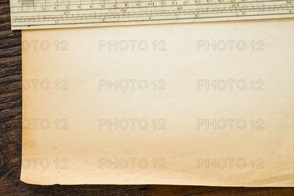 Old brown paper with ruler, studio shot.