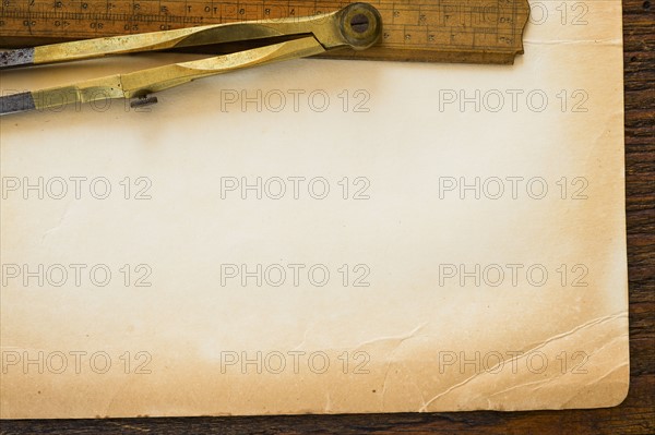 Old brown paper with ruler and compass, studio shot.