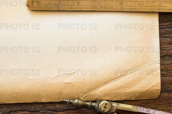 Old brown paper with ruler and compass, studio shot.