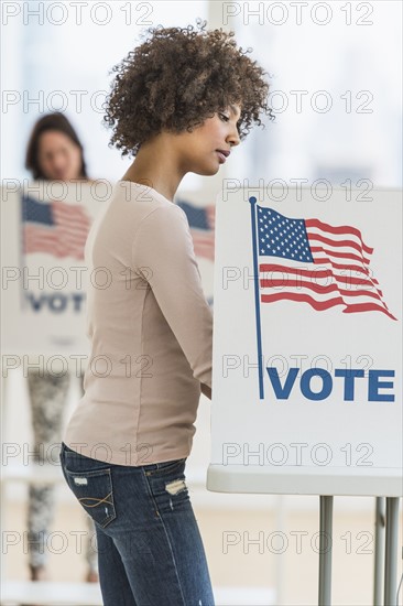 Woman in voting booth.