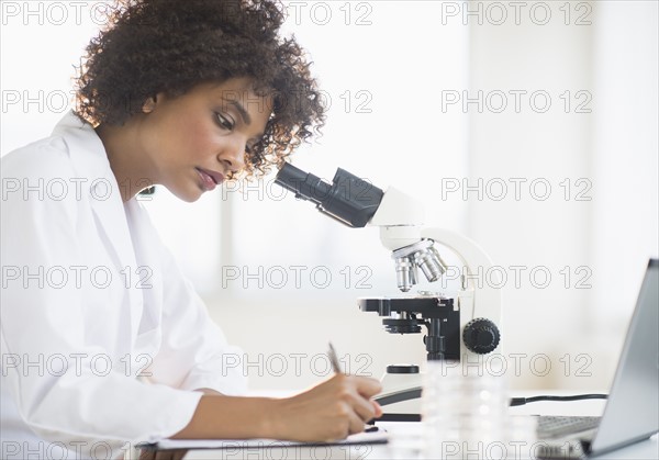 Woman using microscope in laboratory.