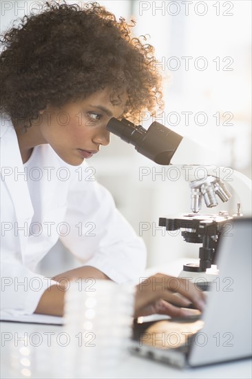 Woman using microscope in laboratory.