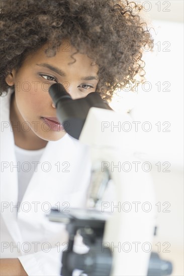 Woman using microscope in laboratory.