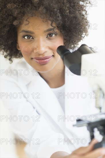 Woman using microscope in laboratory.