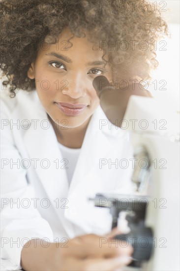 Woman using microscope in laboratory.