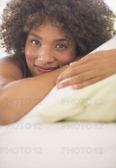 Portrait of woman lying on bed.