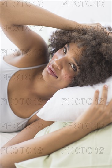 Portrait of woman lying on bed.