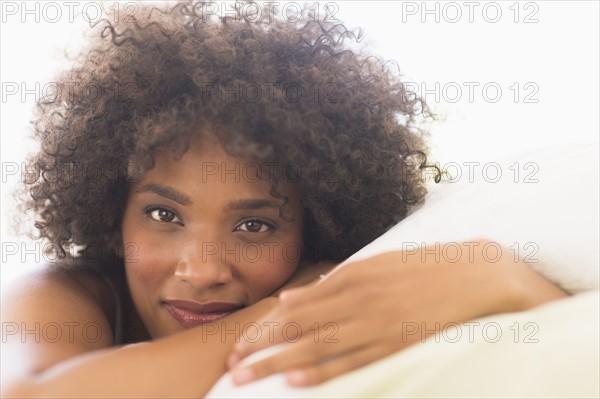 Portrait of woman lying on bed.