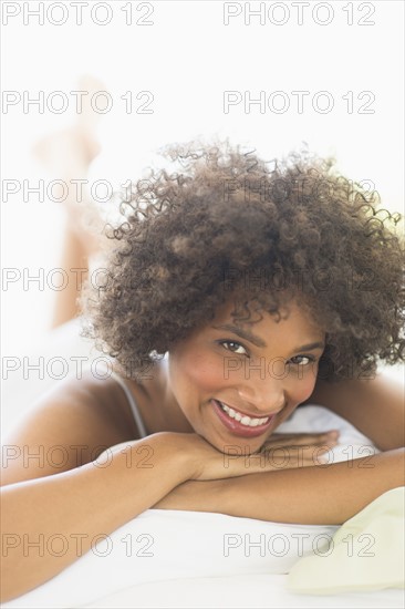 Portrait of woman lying on bed.