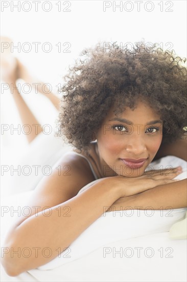 Portrait of woman lying on bed.