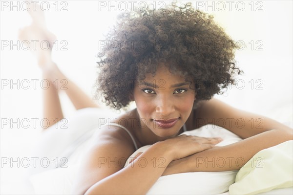 Portrait of woman lying on bed.