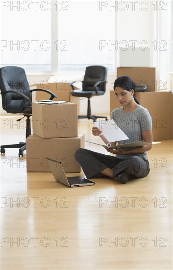 Businesswoman reading documents in new office.