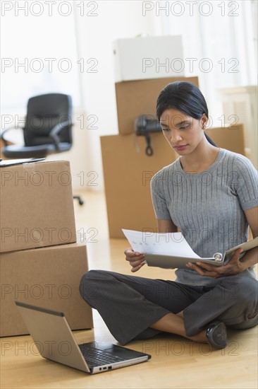 Businesswoman reading documents in new office.