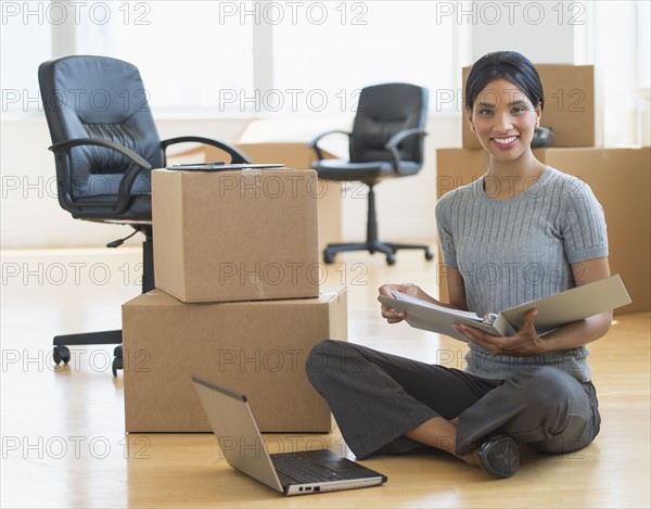 Businesswoman reading documents in new office.