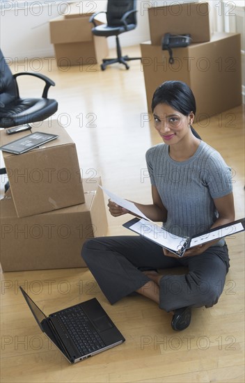 Businesswoman reading documents in new office.