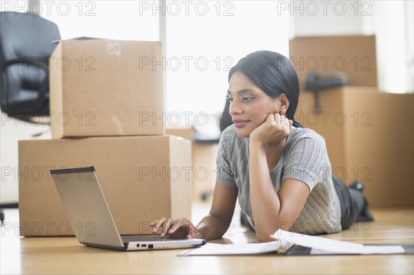 Businesswoman using laptop in new office.