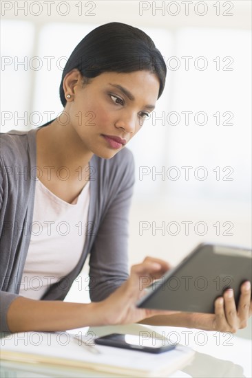 Businesswoman using digital tablet in office.