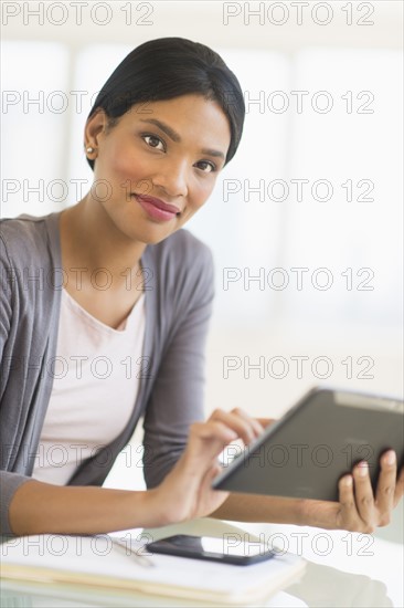 Businesswoman using digital tablet in office.