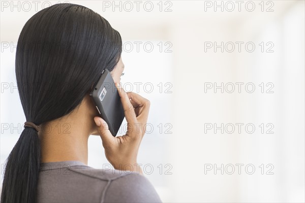 Businesswoman talking on phone, studio shot.