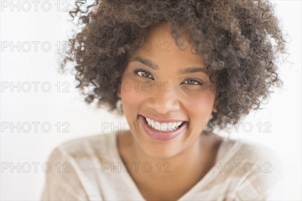 Portrait of woman laughing, studio shot.