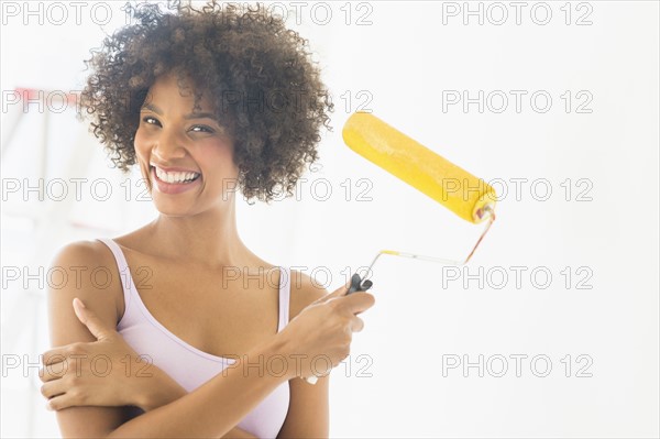 Portrait of woman holding paint roller.