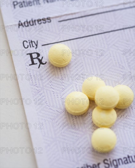 Yellow pills with prescription form, studio shot.