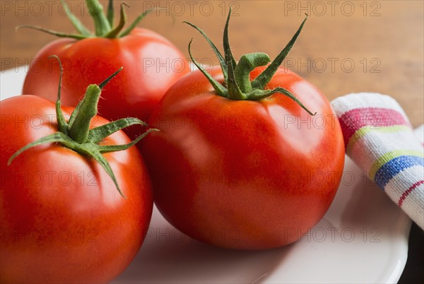 Tomatoes on plate, studio shot.