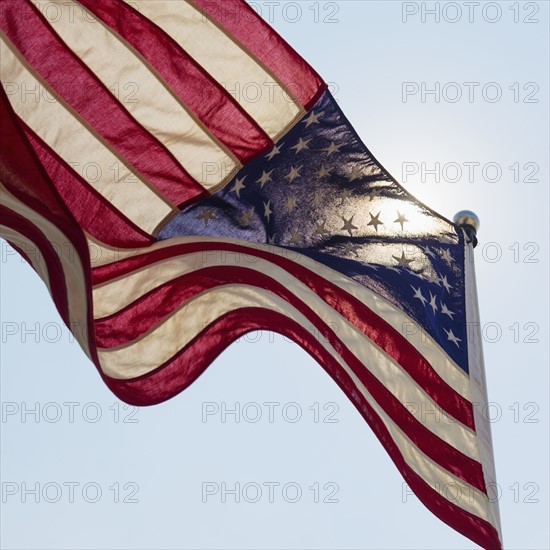 US flag against blue sky.