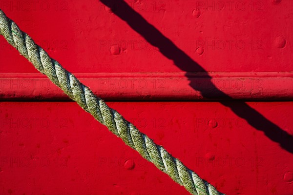 Detail of red tugboat with rope.