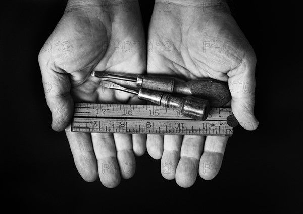 Studio shot of hands holding antique tools.