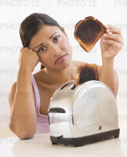 Studio shot of woman holding burnt toast.