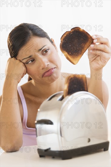 Studio shot of woman holding burnt toast.