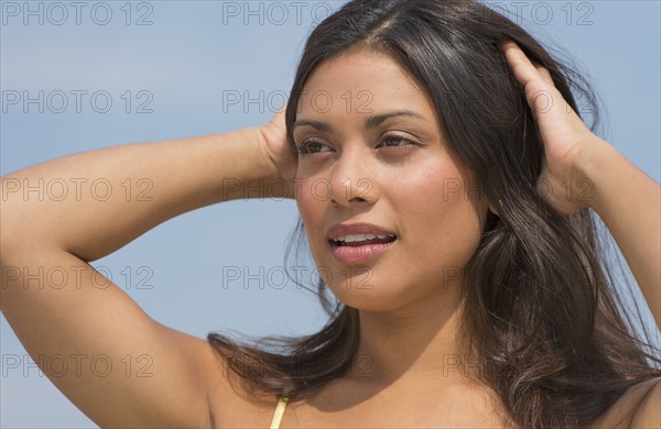 Young woman with hands in hair.