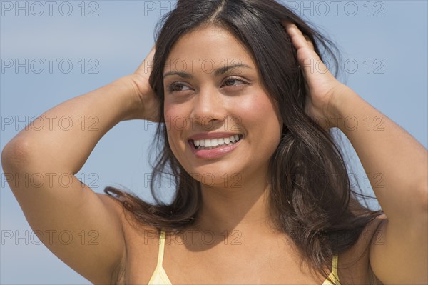 Young woman with hands in hair.