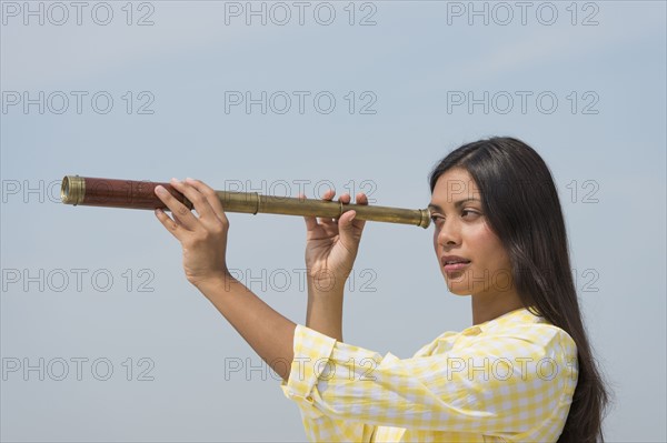 Woman looking through telescope.