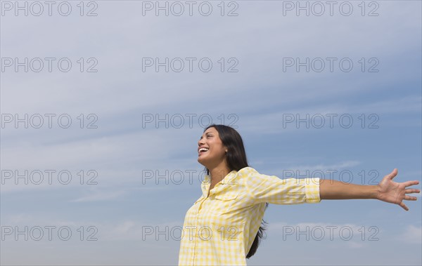 Happy woman against blue sky .